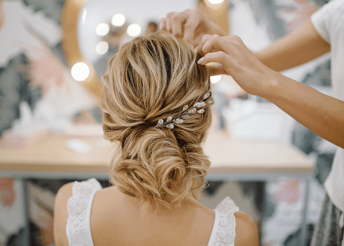 Woman's hair in an elegant updo with decorative hairpiece, styled by a professional.