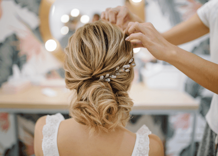 Woman's hair in an elegant updo with decorative hairpiece, styled by a professional.